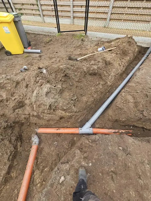 Nieuwe PVC-afvoerleidingen in de sleuf