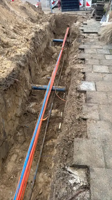 Kabels in de sleuf langs de stoep