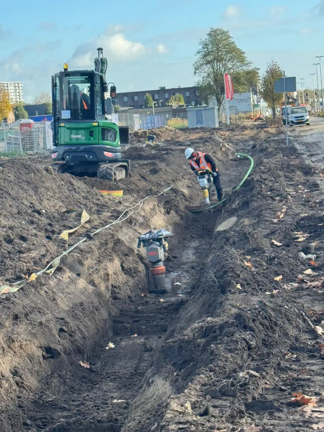 Minigraver en trilplaat in de sleuf