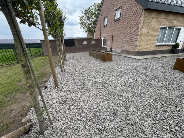 Bomenrij en grind bij de woning
