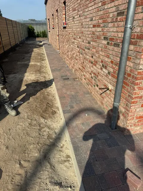 Nieuw pad langs de gevel en de schutting