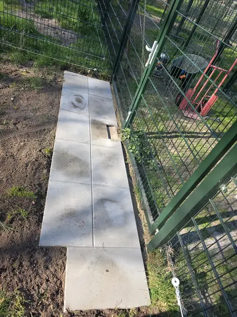 Tegelpad langs het hekwerk