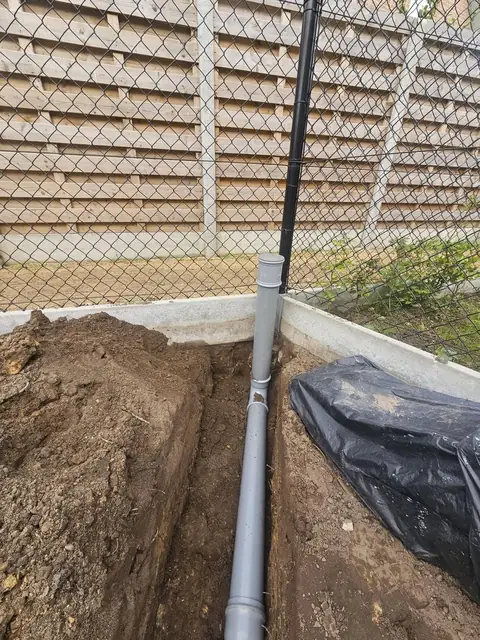 Regenpijp langs de schutting aangesloten